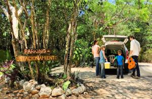 a group of people standing next to a car at CAMP AKUMAL - Hosted Family Bungalows in Akumal