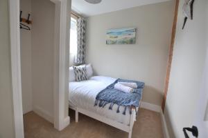 a small room with a bed with a window at The Old Tailors Cottage in Long Whatton +1 photo