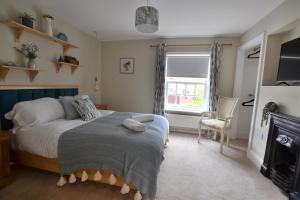 um quarto com uma cama e uma janela em The Old Tailors Cottage em Long Whatton