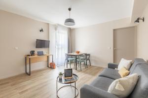 a living room with a couch and a table at Appart'City Classic Valence in Valence