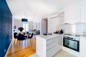 eine Küche mit weißen Schränken und ein Esszimmer in der Unterkunft Blue by the River 3 - elegant two-bedroom in Santos in Lissabon