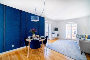 Blue by the River 3 - elegant two-bedroom in Santos في لشبونة: غرفة طعام بجدران زرقاء وطاولة وكراسي