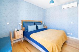 ein Schlafzimmer mit einem Bett und einer blauen Wand in der Unterkunft Blue by the River 3 - elegant two-bedroom in Santos in Lissabon