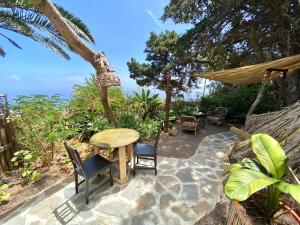 eine Terrasse mit einem Tisch, Stühlen und Meerblick in der Unterkunft Studio Mazo The Glamping in Lodero