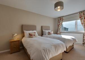 two beds in a bedroom with a window at Watercrag in Gunnerside