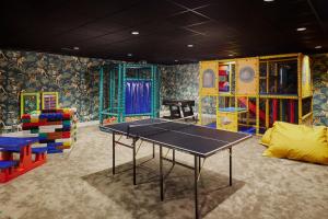 a ping pong table in a room with colorful furniture at Van der Valk Palace Hotel Noordwijk in Noordwijk aan Zee
