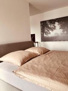 a bedroom with two beds and a painting on the wall at Studio-Apartment Hohe Börde in Irxleben