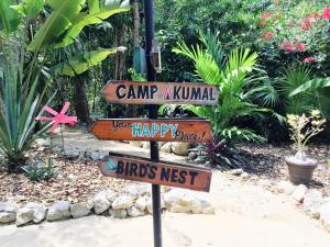 Ein Straßenschild, auf dem Camp Kunnel und glückliche Vögel nisten in der Unterkunft CAMP AKUMAL - Hosted Family Bungalows in Akumal