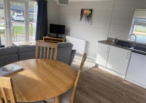 ein Wohnzimmer mit einem Holztisch und einer Küche in der Unterkunft Walkers Retreat in Routh