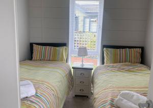 two beds in a room with two windows at Walkers Retreat in Routh