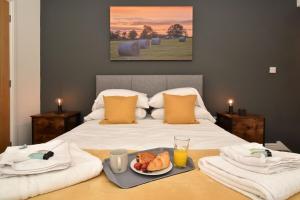 Un dormitorio con una cama con una bandeja de comida. en Pinfold Suite - Chester Road Apartments By, en Macclesfield