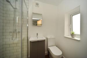 Baño blanco con aseo y lavamanos en Pinfold Suite - Chester Road Apartments By, en Macclesfield