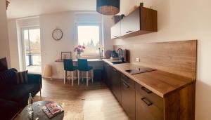 a kitchen with a counter and a table with blue chairs at Studio-Apartment Hohe Börde in Irxleben