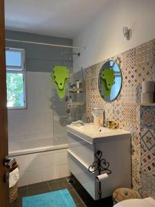 een badkamer met een wastafel en een douche met een spiegel bij להרגיש בבית in Ramat Shlomo