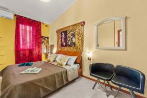 a bedroom with a bed with a mirror and two chairs at Villa Angela in Quartu SantʼElena +22 photos