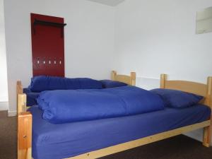 uma cama com almofadas azuis em cima em Tobermory Youth Hostel em Tobermory