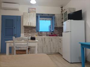 モコロスにあるRemezzoのキッチン(白い冷蔵庫、テーブル付)