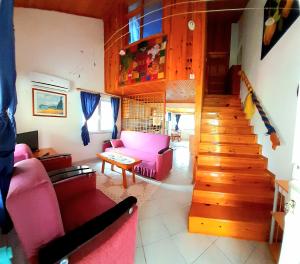 キラリにあるÇıralı Rüya Pansiyonのリビングルーム(ピンクの家具、階段付)