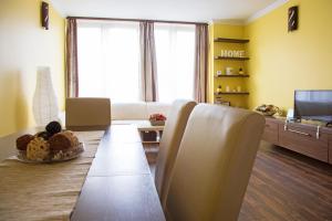 a living room with a table and a couch and a television at Golden apartman in Gyula