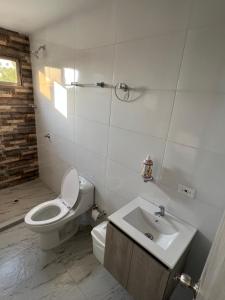 a white bathroom with a toilet and a sink at Hermoso apartamento central in Montería +11 photos