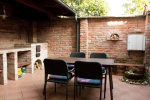 patio con mesa, sillas y pared de ladrillo en Golden apartman en Gyula