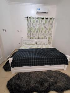 a bedroom with a black and white bed with a window at SUCCESS ROOM Ensuit - East Legon, Adjiringanor in Accra