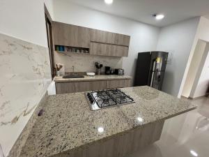 - une cuisine avec un plan de travail en granit et une cuisinière dans l'établissement Hermoso apartamento central, à Montería