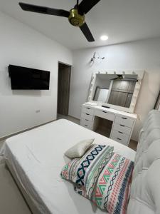 een slaapkamer met een bed, een wastafel en een plafondventilator bij Hermoso apartamento central in Montería