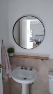 y baño con lavabo blanco y espejo. en CasaNorte Hospedaje en Miraflores, Catamarca 