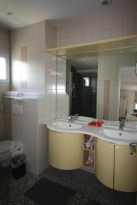 łazienka z 2 umywalkami i dużym lustrem w obiekcie Chambres d'Hôtes LA PASTOURELLE Royan centre w mieście Royan