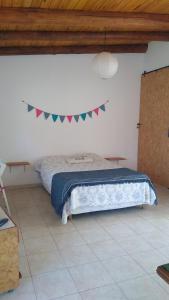 1 dormitorio con 1 cama con una pancarta en la pared en CasaNorte Hospedaje en Miraflores, Catamarca 