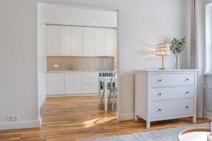 a kitchen with white cabinets and a dining room at Spacious Family Friendly apartment, Free Parking in Tallinn