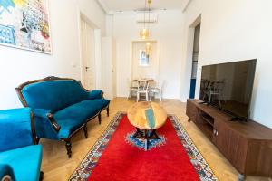 ein Wohnzimmer mit einem blauen Sofa und einem roten Teppich in der Unterkunft Luxury Suite / Josip Vancaš in Sarajevo