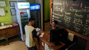 two men standing at a cash register in a restaurant at Aji Hostel in Santiago