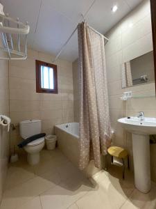 uma casa de banho com uma banheira, um WC e um lavatório. em P&R hostals Codolar em Tossa de Mar