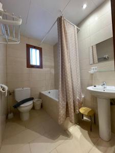 een badkamer met een bad, een toilet en een wastafel bij P&R hostals Codolar in Tossa de Mar