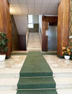 un pasillo con escaleras y una alfombra verde en un edificio en Milano city life en Milán