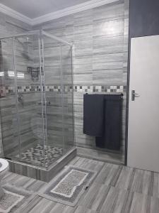 a shower stall in a bathroom with a toilet at Ariah's Guesthouse and Self Catering in East London