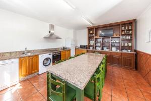 una cocina con una isla grande con toques verdes en El Pongallin ideal para familias, en Sevares