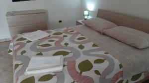 a bedroom with a bed with a comforter and a chair at ORO BIANCO in Marsala