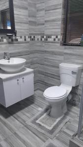 Ariah's Guesthouse and Self Catering في شرق لندن: حمام مع مرحاض أبيض ومغسلة