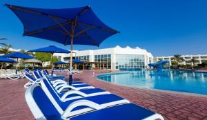uma fila de espreguiçadeiras azuis e brancas junto a uma piscina em Aurora Oriental Resort Sharm El Sheikh em Sharm el Sheikh