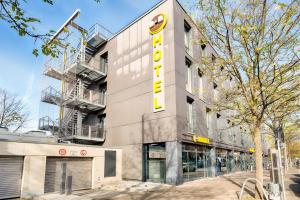 ein Gebäude mit einem gelben Schild an der Seite in der Unterkunft B&B Hotel München-Moosach in München