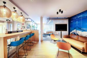 a living room with a bar and a couch at B&B HOTEL München-Airport in Hallbergmoos