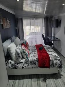 a bedroom with a bed with a red blanket on it at Ariah's Guesthouse and Self Catering in East London