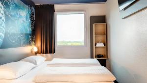 Postel nebo postele na pokoji v ubytování B&B Hotel München-Garching