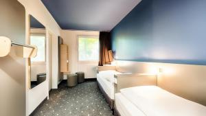 Postel nebo postele na pokoji v ubytování B&B Hotel München-Garching