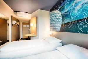 Postel nebo postele na pokoji v ubytování B&B Hotel München-Garching