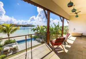 a balcony with a tub and a view of the ocean at JA Enchanted Waterfront Seychelles in Mahe