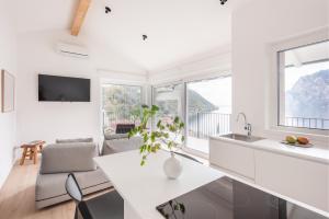 ナーゴ・トルボレにあるApartment Bellavistaのキッチン、白い壁と窓のあるリビングルーム